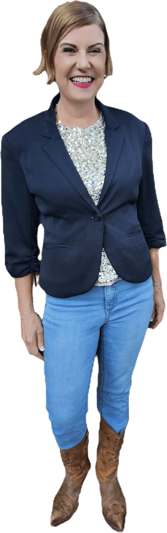 Rachel Muir beams in a chic navy blazer and sparkling top, paired with denim and stylish cowboy boots, radiating warmth and laughter as she inspires nonprofit fundraising success.