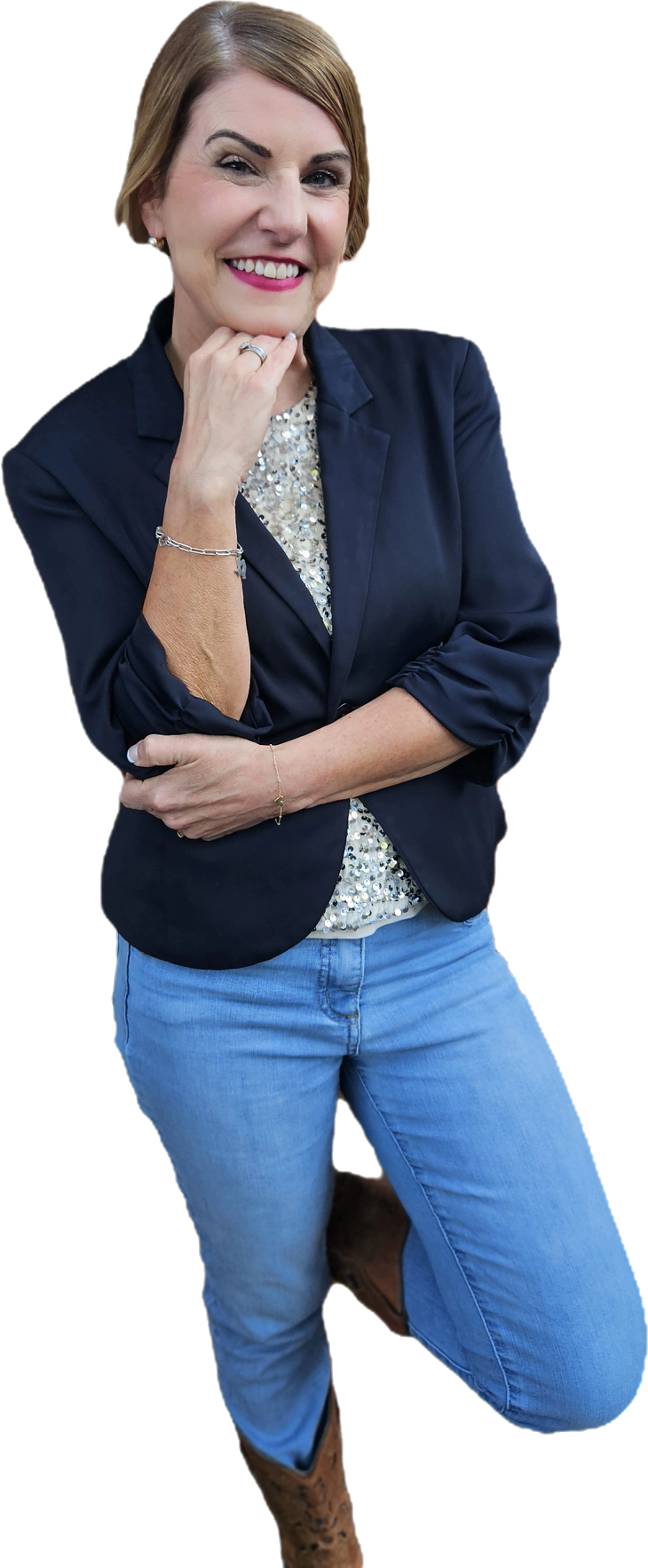 Rachel Muir, a vibrant nonprofit fundraising consultant, smiles confidently in a navy blazer over a sparkling shirt, showcasing her fun personality amid a bright, engaging background.