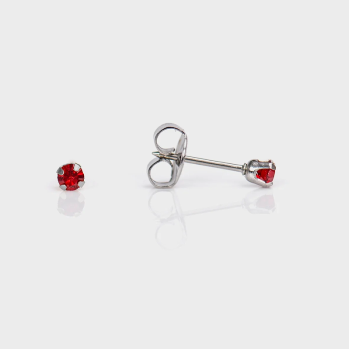 Pair of silver stud earrings with red gemstones, one earring's gemstone loose and the other attached to the earring back.