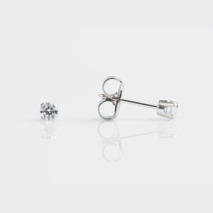 A pair of silver stud earrings with clear gemstones against a white background, with one earring lying flat and the other showing the back and post.