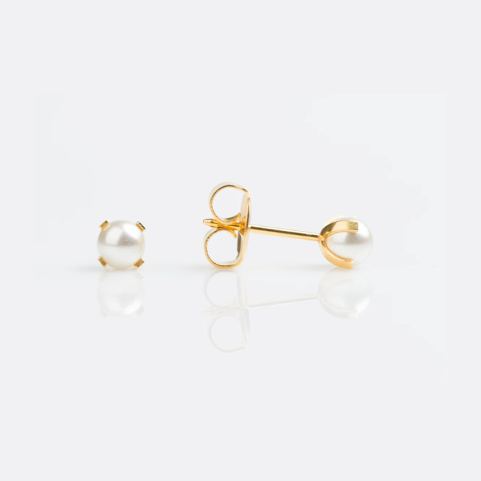 Close-up of a pair of pearl earrings with gold settings, one earring with the pearl facing forward and the other showing the back and post.