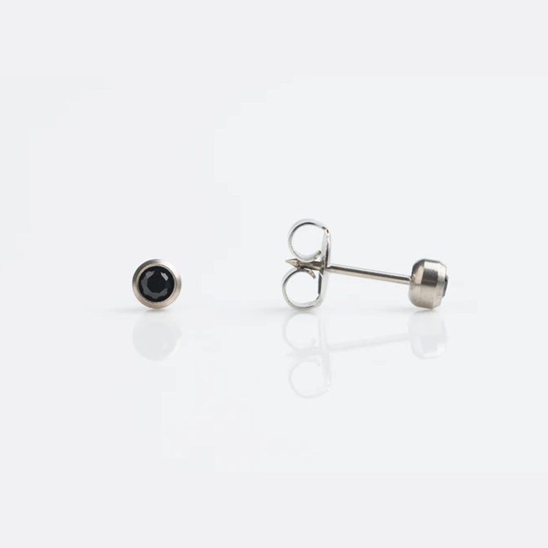 Silver stud earrings with black gemstones on white background