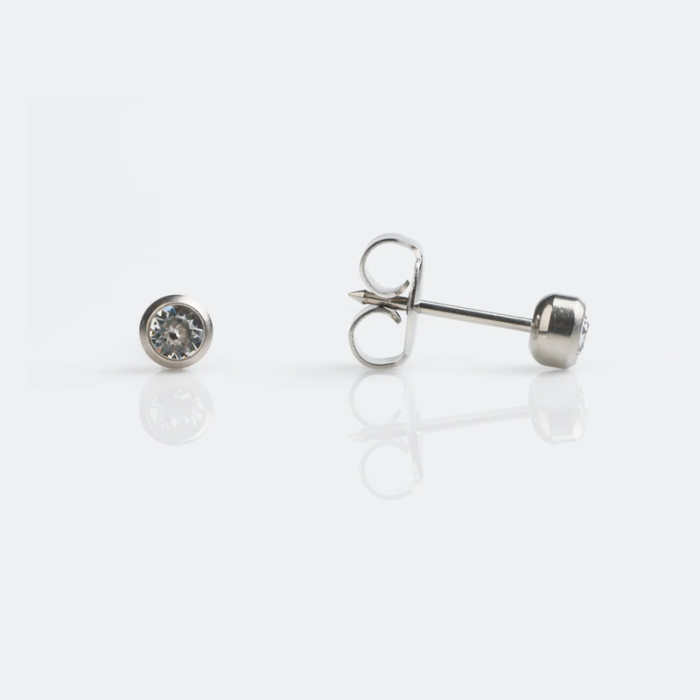 Silver stud earrings with clear gemstones on a white surface.