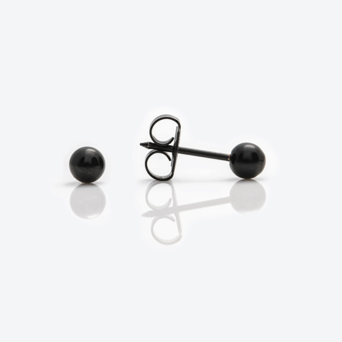 Two black ball-shaped pins, one with a backing, on a white surface.