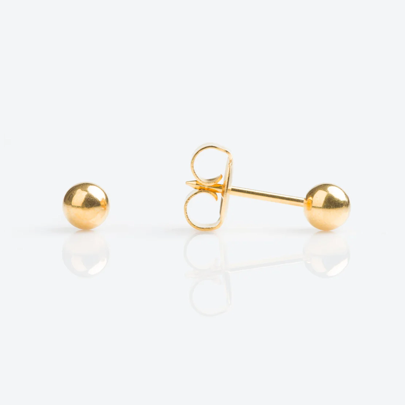 Gold stud earrings with a spherical shape on a white background.