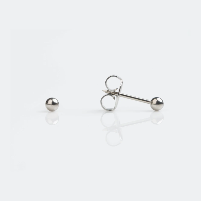 Silver stud earrings on a white background, one earring with a post and butterfly back, the other a loose ball.