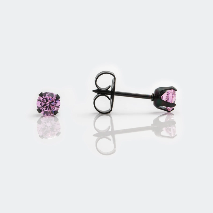Pair of pink gemstone stud earrings, one facing forward and one lying on its side with a black metal setting, on a reflective white surface.