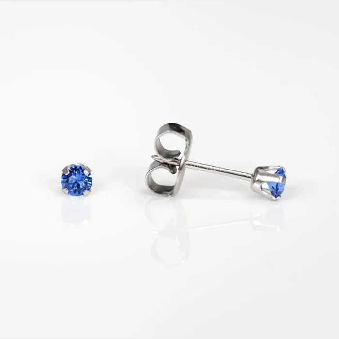 Pair of silver stud earrings with blue gemstones on a white surface.