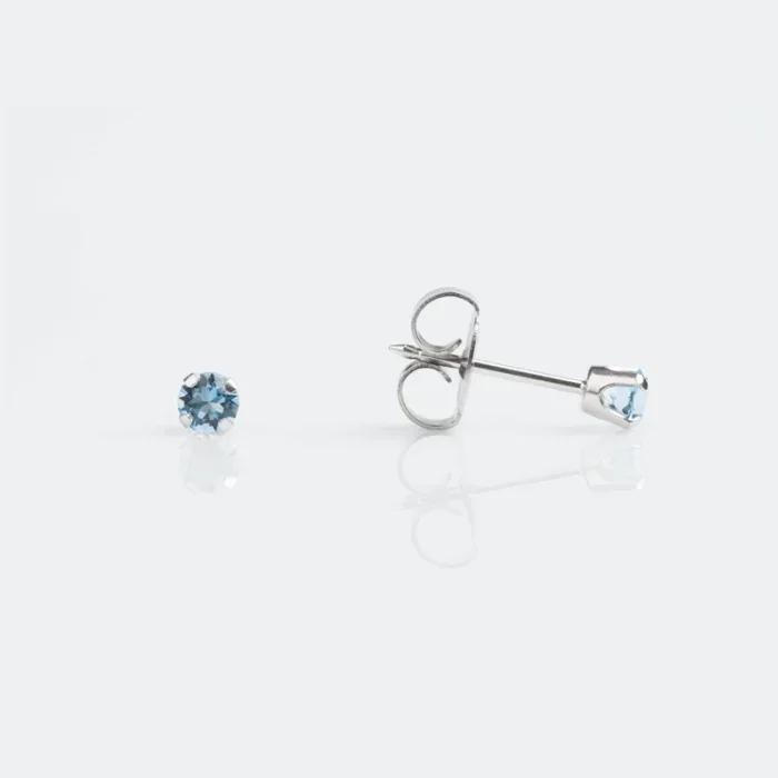 Pair of silver earrings with light blue gemstones on a white background