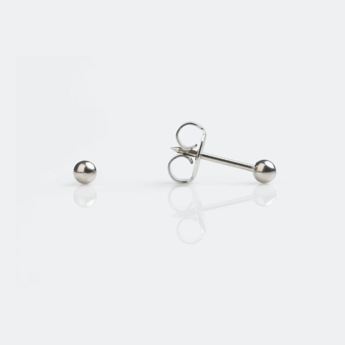 A pair of silver stud earrings on a white surface, with one earring lying flat and the other resting on its side showing the back clasp.