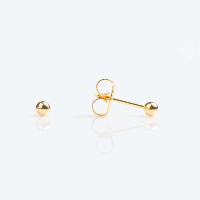Two gold stud earrings, one with a removable back and the other with the post and backing separated, on a white surface.