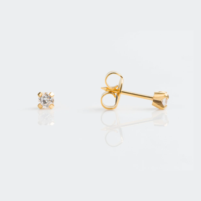 A pair of gold stud earrings with small diamonds on a white reflective surface, showing front and back views.