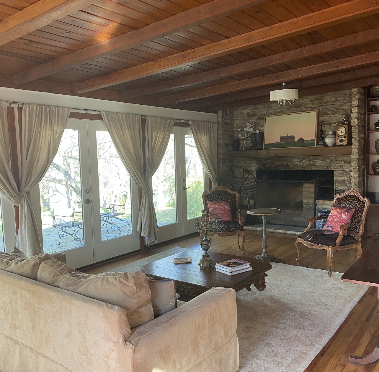 Luxury vacation rental living room with floor-to-ceiling windows, a stunning fireplace, elegant furnishings, and a bright, inviting atmosphere designed for guest comfort.
