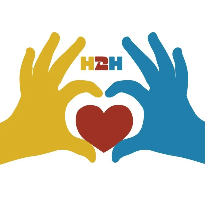 Two hands, one yellow and one blue, forming a heart shape around a red heart. The text 'H2H' is positioned above the heart, with 'H' in yellow and '2H' in red and blue.