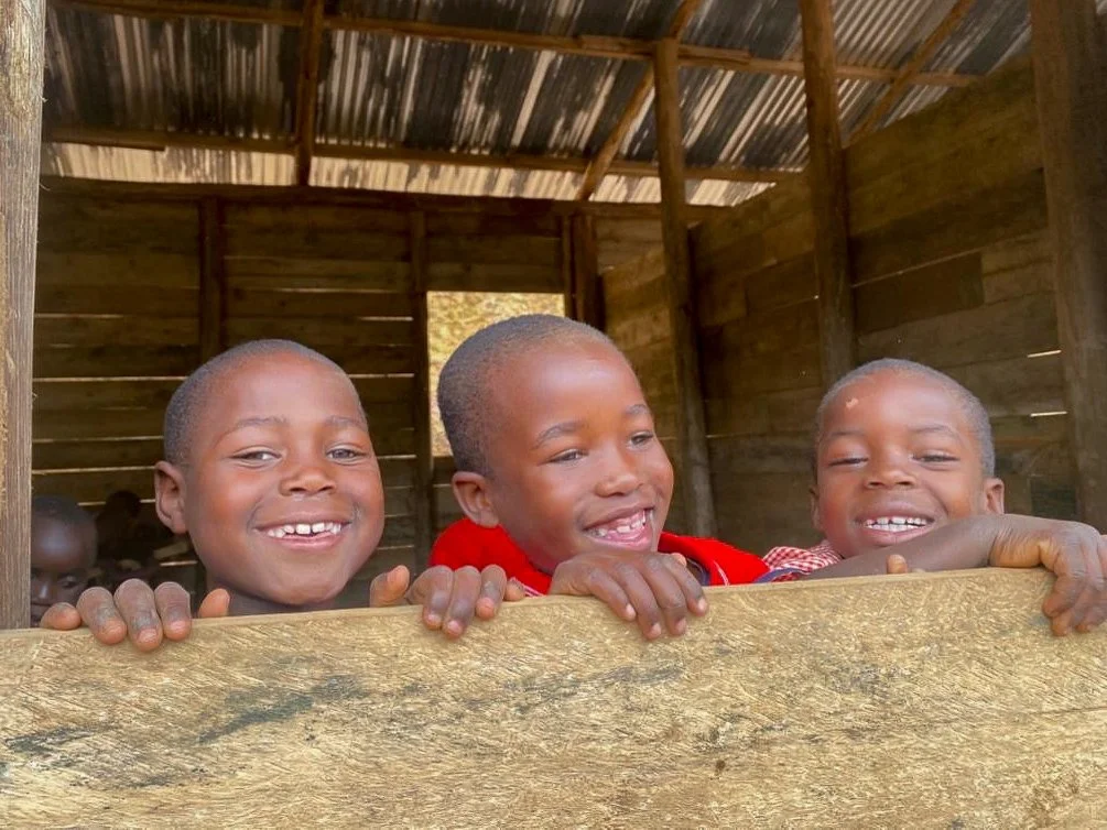 Three smiling Batwa boys in Heart 2 Heart School