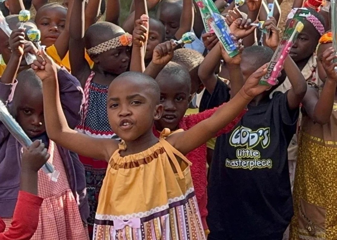 Batwa children holding up toothbrushes donated by Johnston Dental Care in Grants Pass, Oregon