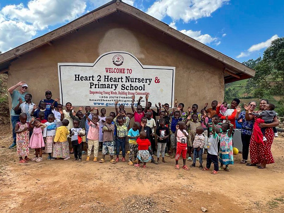 Batwa children and their teachers along with Bob & Gloria Cooper Directors of H2H Intl. standing in front of the Heart 2 Heart School for Batwa children.