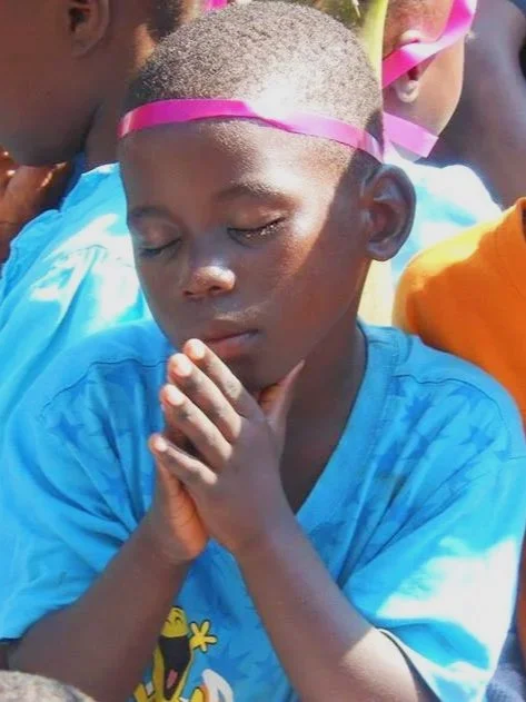 Small boy praying with his eyes closed