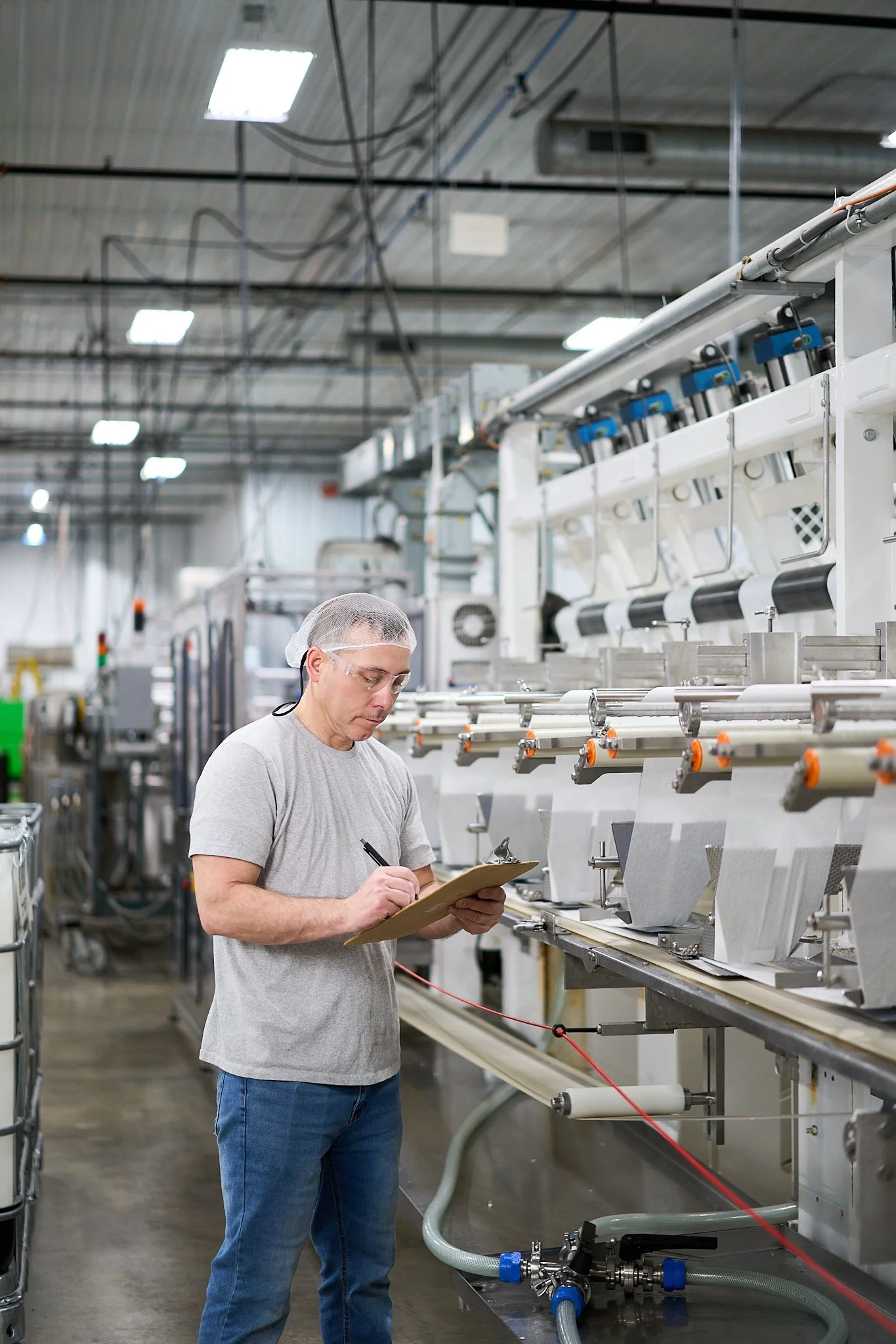 Employee inspecting wipe manufacturing machine.