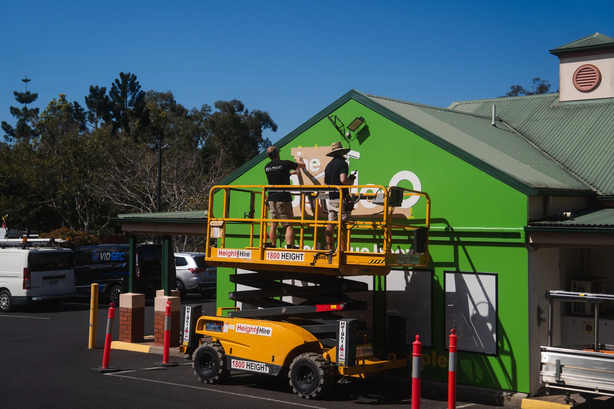 Workers installing signage during retail fitout project