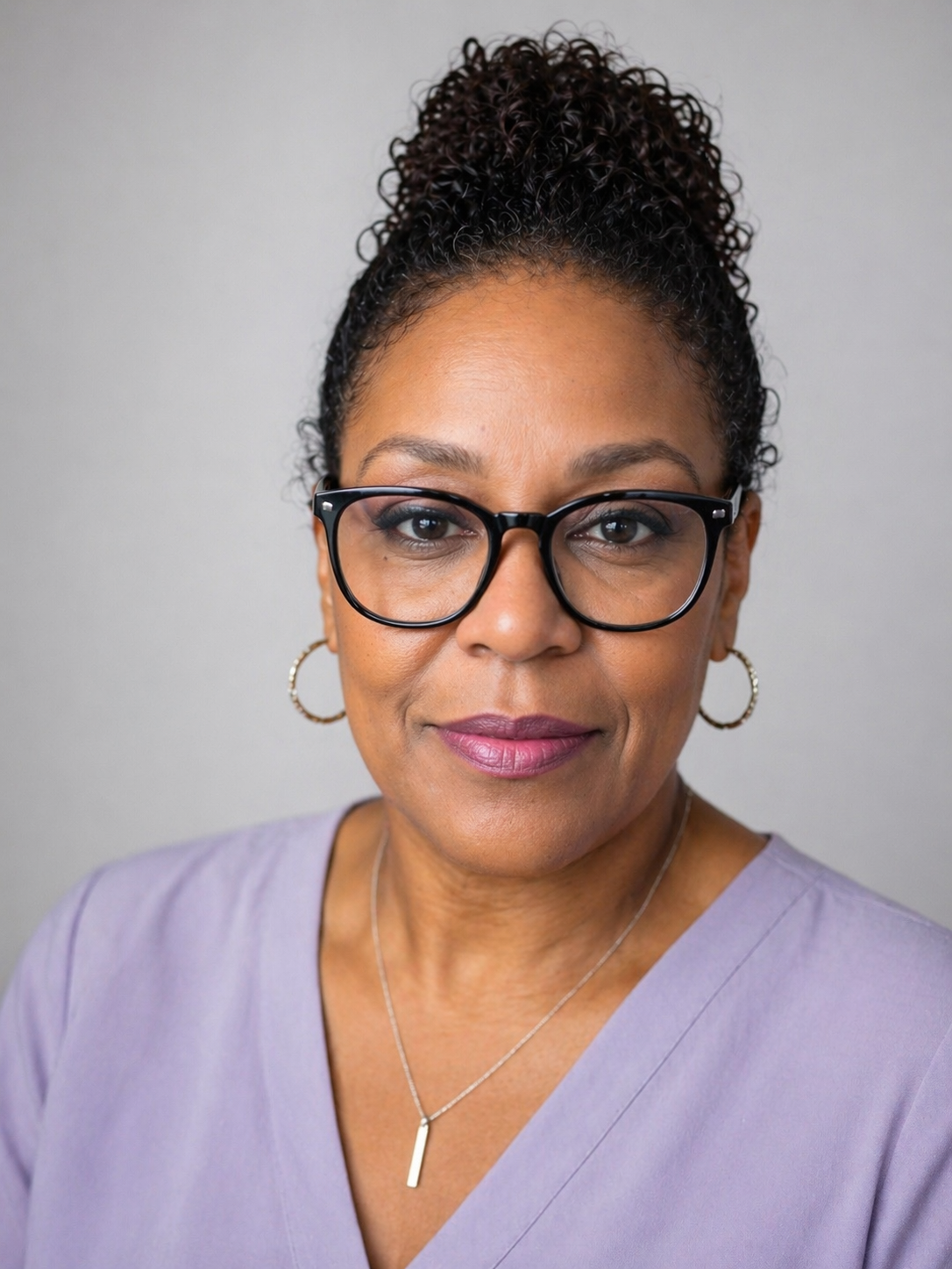 Portrait of Rita LaBrew, LMFT, wearing glasses and a lavender top.