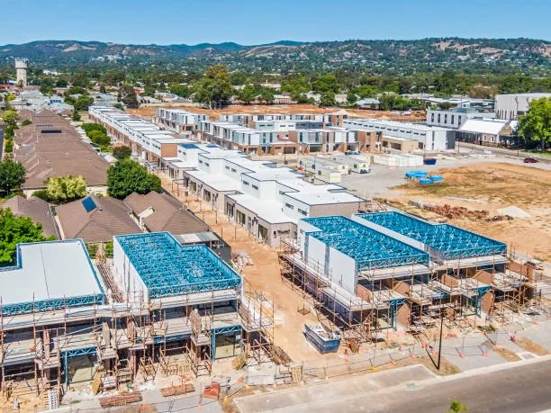 Under construction suburban housing development with multiple row houses and scaffolding