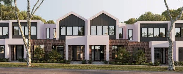 Modern multi-story apartment building with black, pink, and white exterior and large windows, surrounded by trees and a sidewalk.