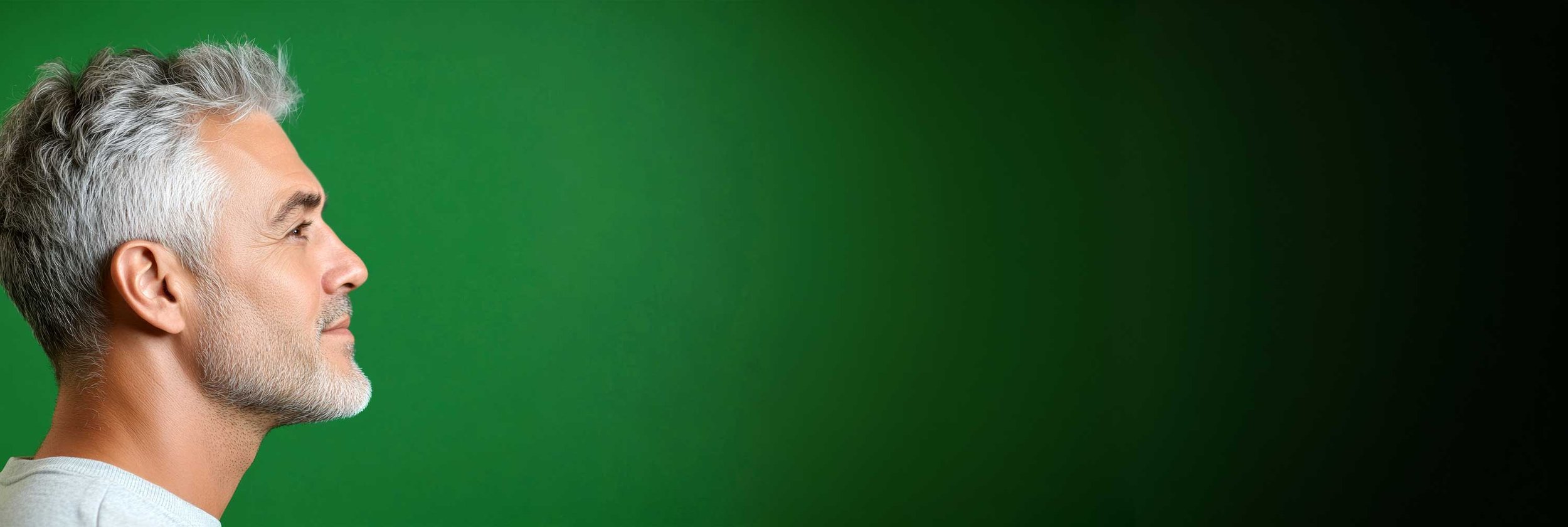 Profile of a senior man with gray hair and beard facing left against a green gradient background.