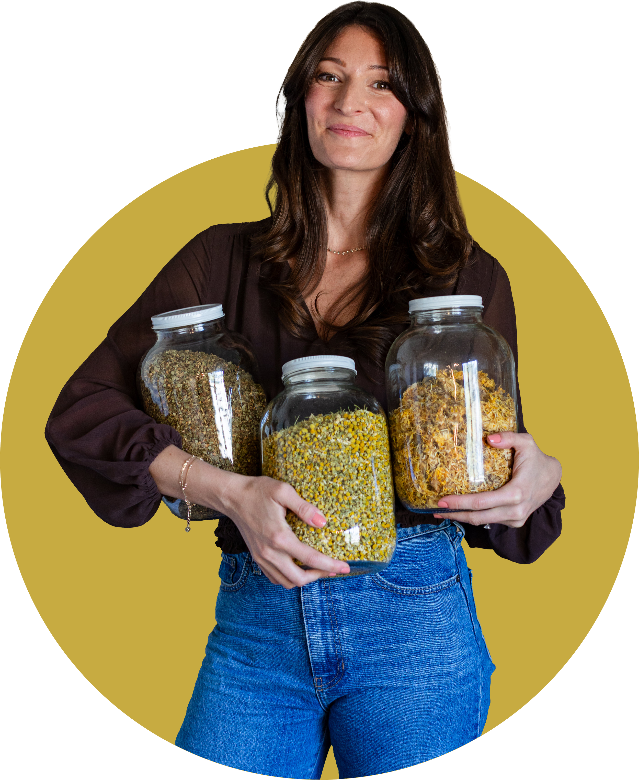 A woman with long brown hair wearing a maroon blouse and blue jeans holds three large glass jars filled with dried herbs or flowers, standing against a yellow circular background.
