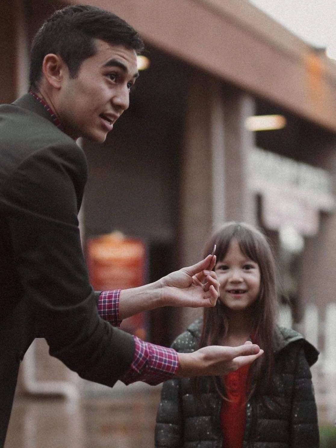 Brady performing coin trick for a girl.