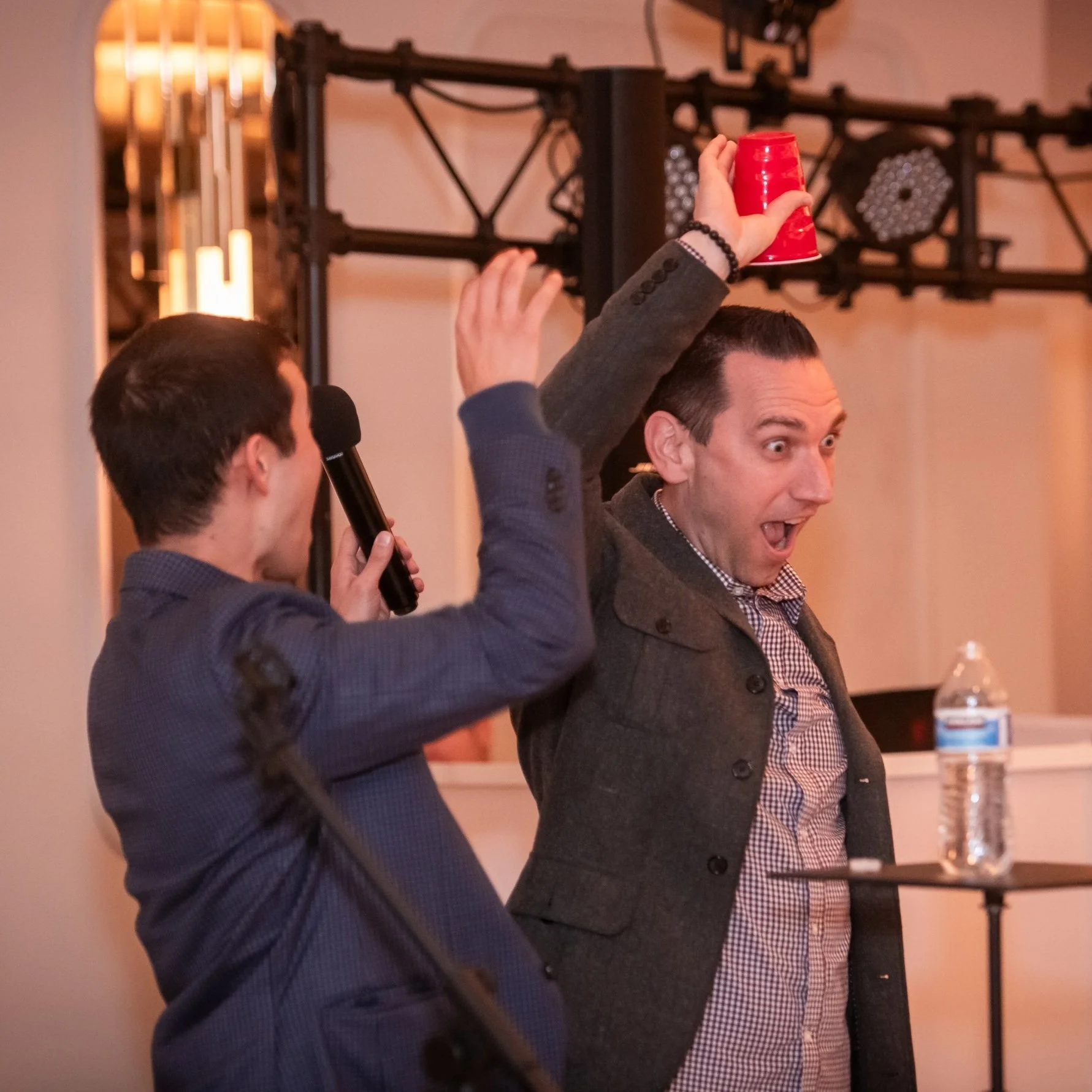 Brady performing magic trick on stage where water vanishes from his spectators cup.