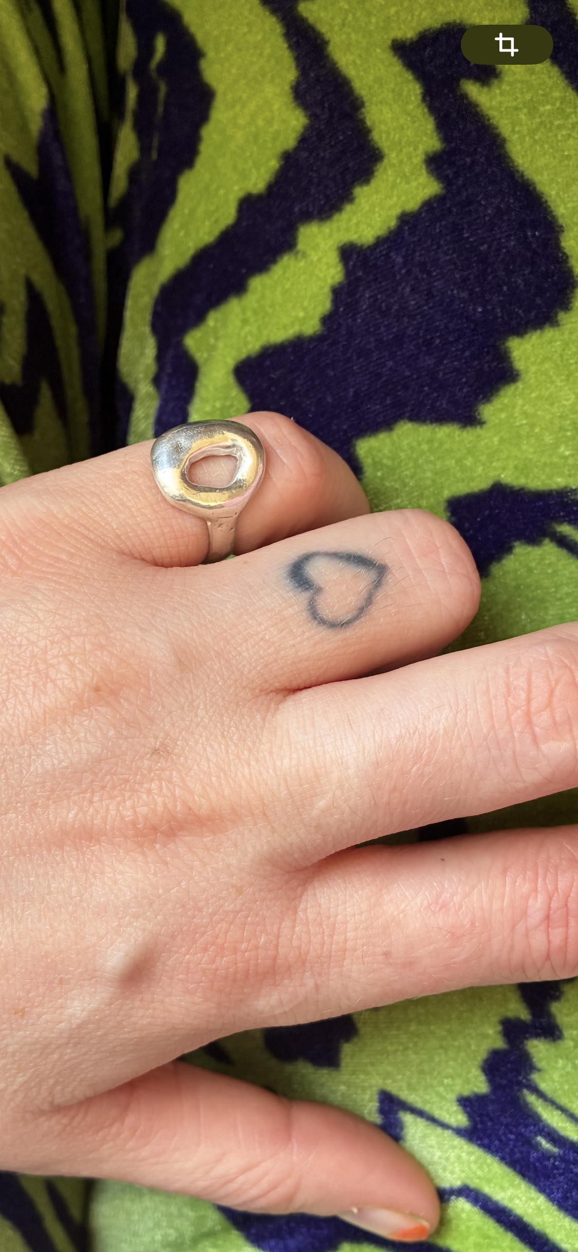 Ring aus Solid Silver auf dem kleinen Finger. Er glänzt und sieht aus wie ein kleiner silberner Donut. Im Hintergrund-Wolken. Der Ring ist das Ergebnis eines Silver Clay Workshops von Studio Jupiter in Hamburg.