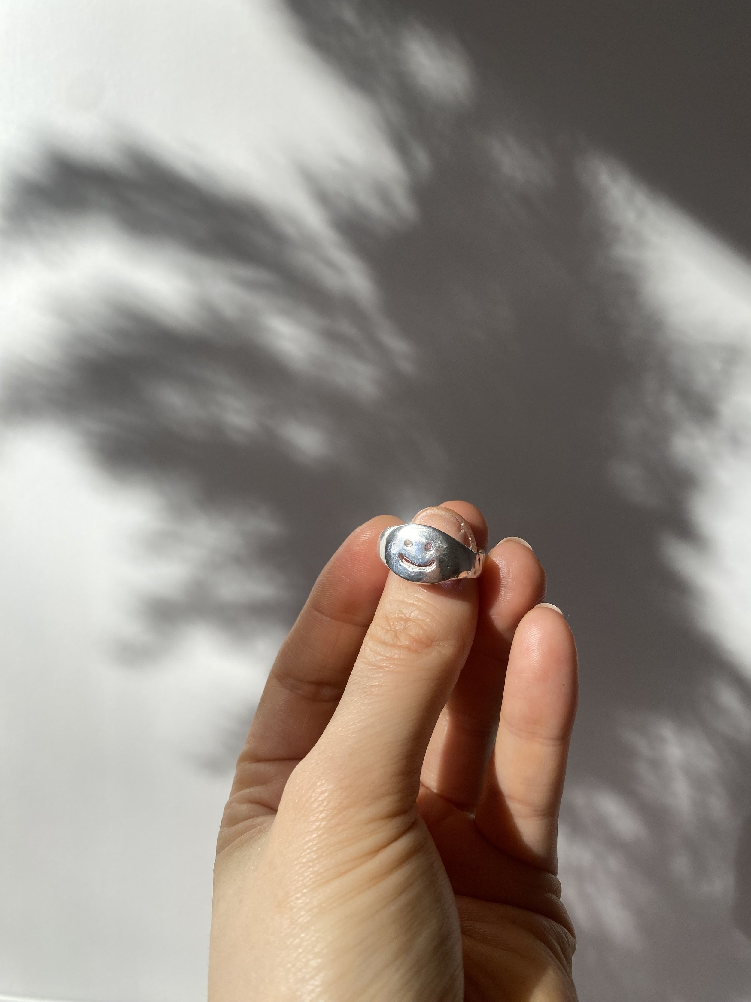 Ring aus Solid Silver mit einem Smiley drauf. Er glänzt und funkelt in der Sonne. Der Ring ist das Ergebnis eines Silver Clay Workshops von Studio Jupiter in Hamburg.