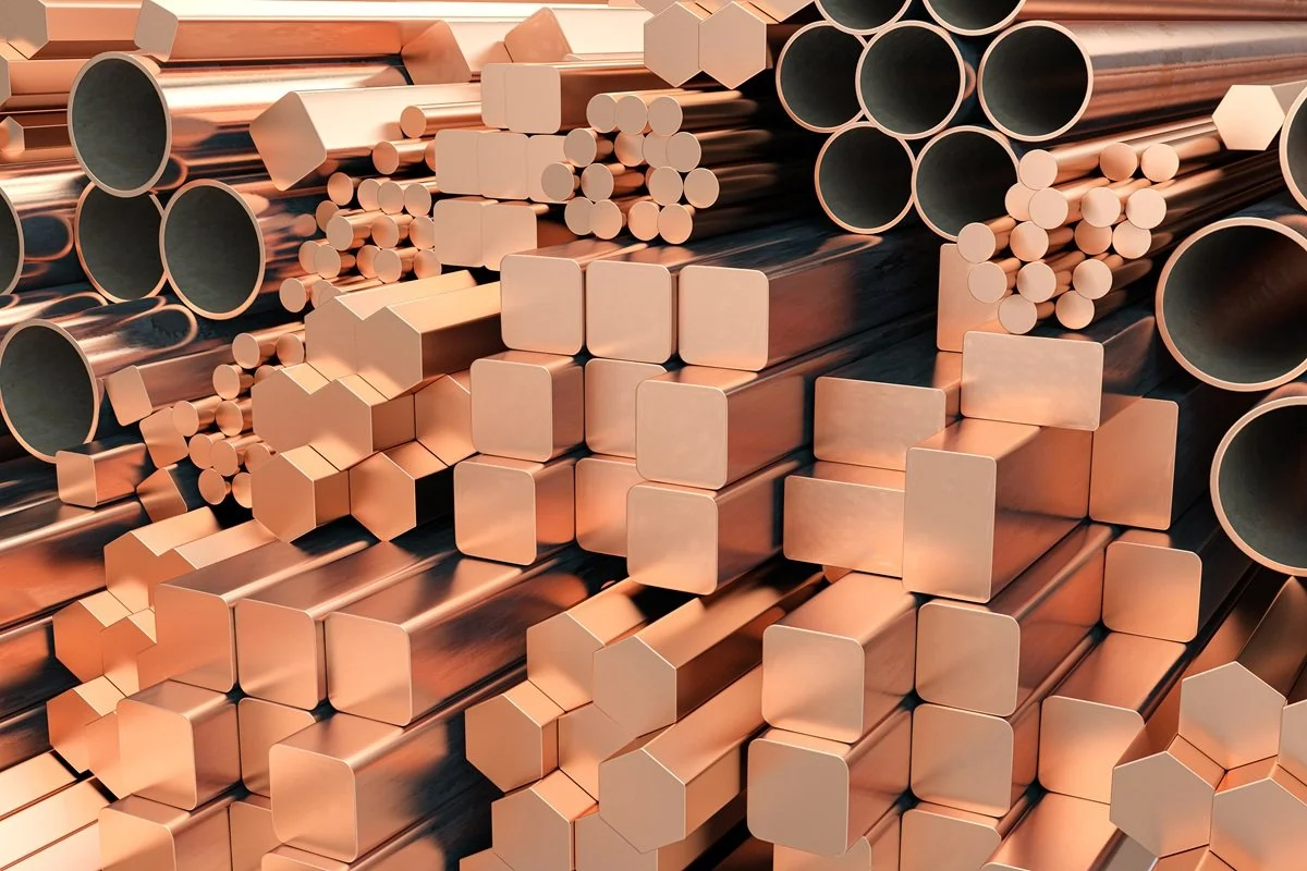 A collection of copper pipes and rods of various shapes and sizes stacked together.