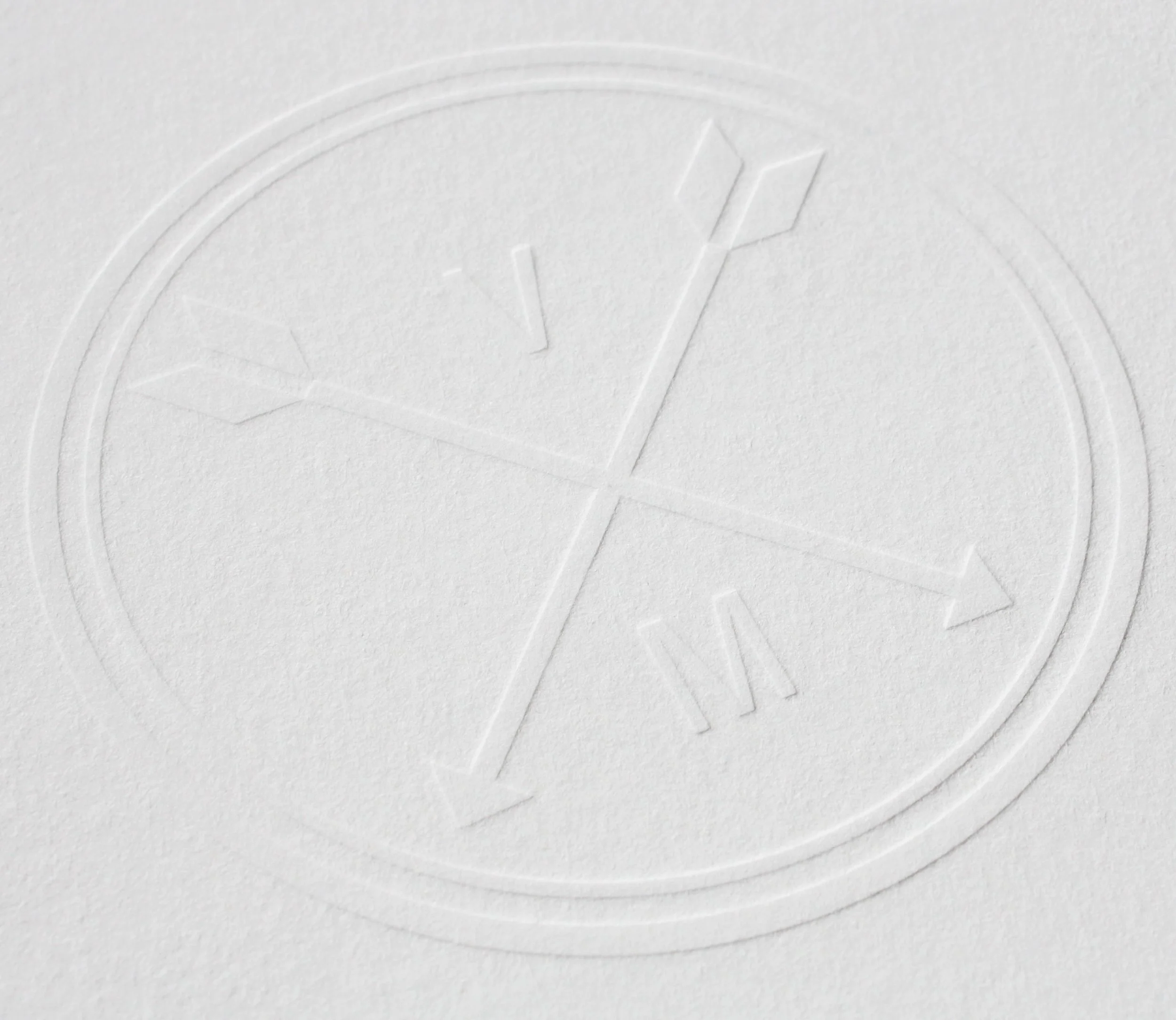 Close-up photo of embossed logo on a white surface.