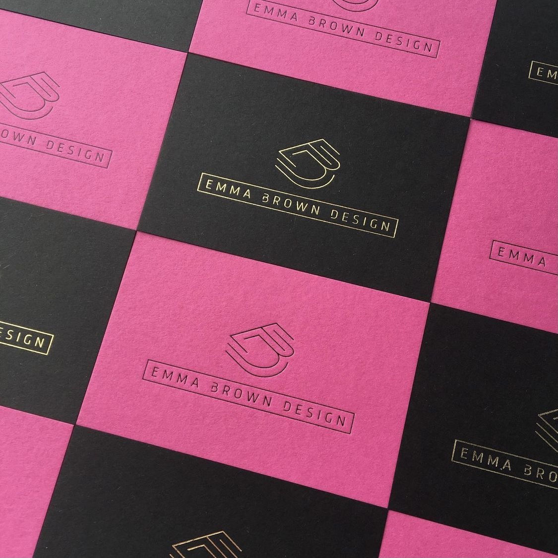 Black and pink business cards with gold and black embossed logo and text for Emma Brown Design.