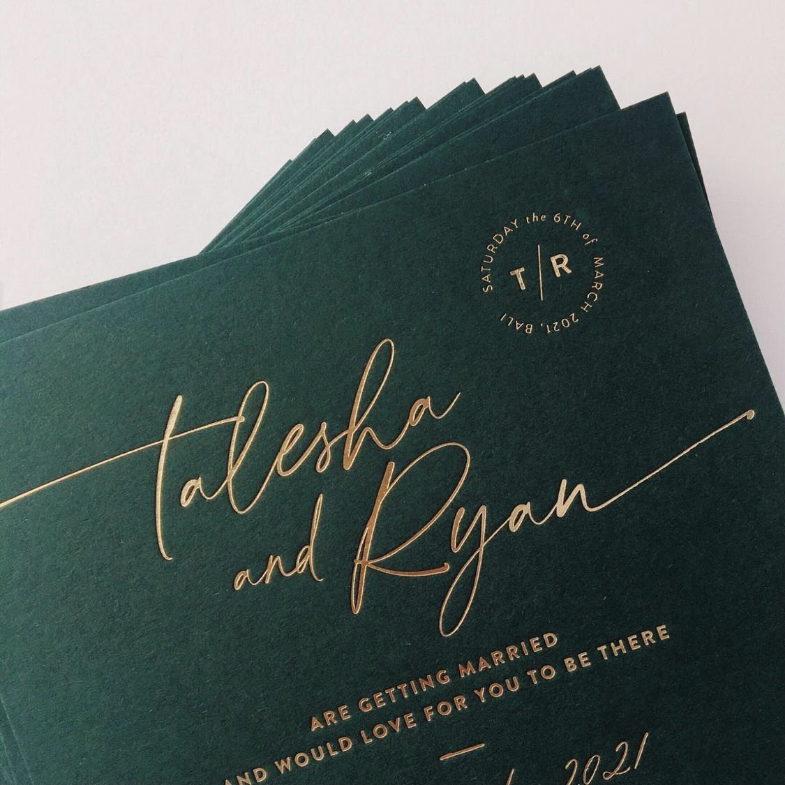 Green wedding invitation card with gold cursive text for Talesha and Ryan, including date and event details.