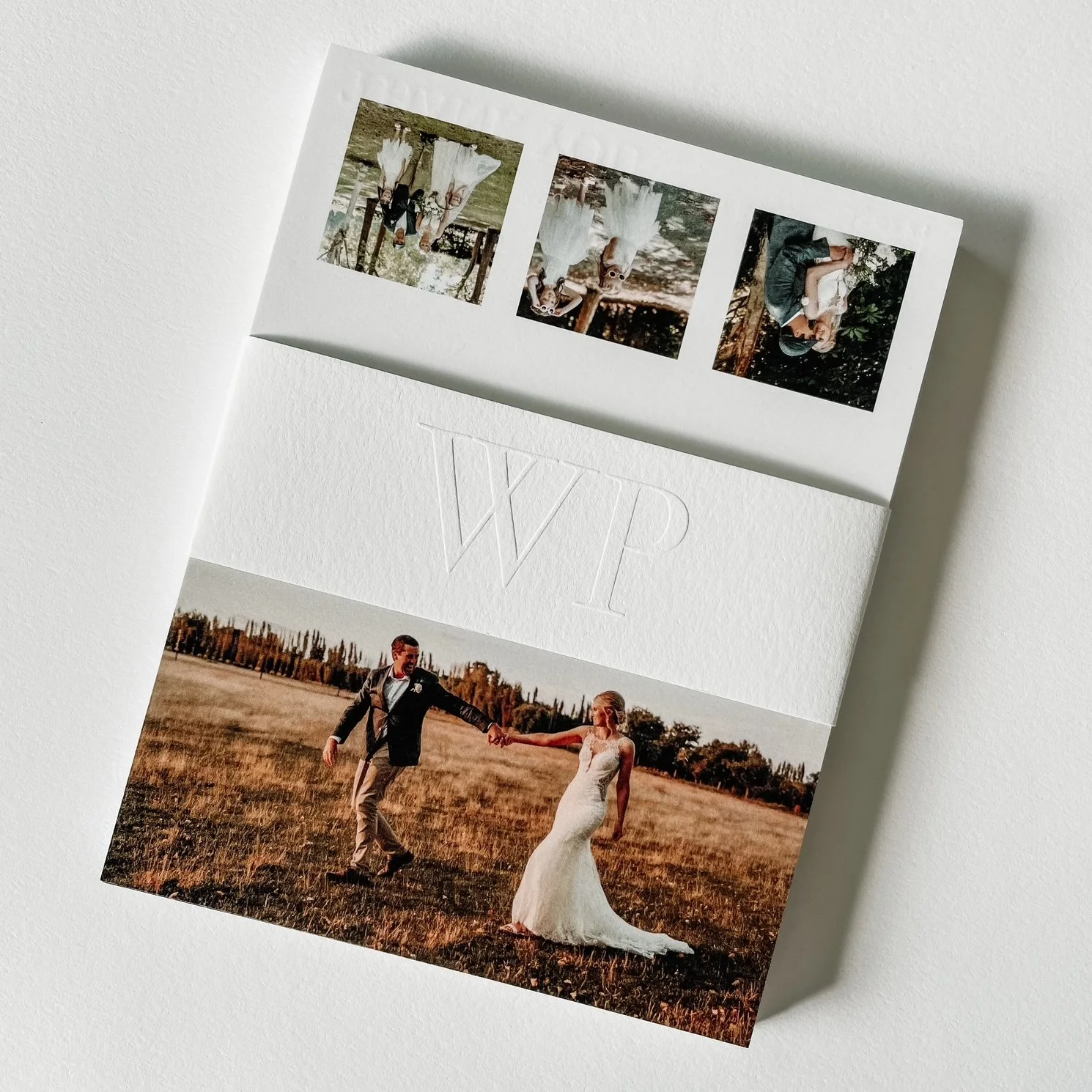 A wedding photo album featuring a picture of a bride and groom holding hands in a field, with other contact sheet photos of wedding moments and a large embossed initials 'VXP' in the center.