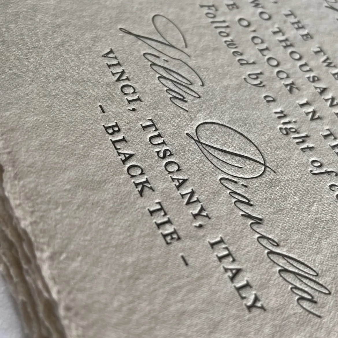 Close-up of embossed text on a textured paper page, showing a signature and words about a wedding or formal event.