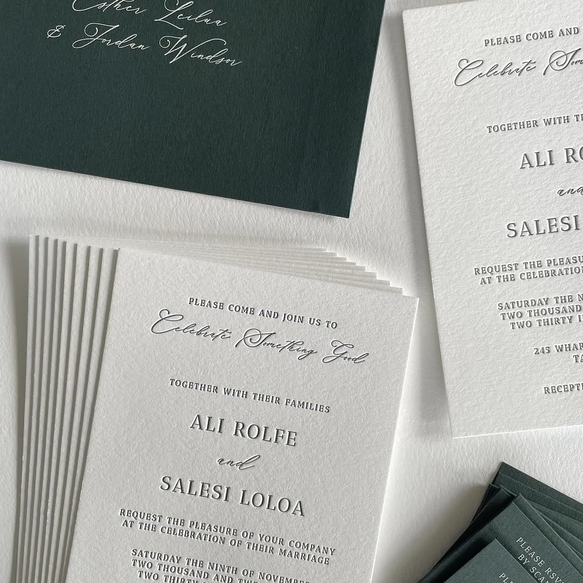 Wedding invitation cards with elegant script and serif fonts, green and white textured paper, and smaller RSVP cards stacked on a white surface.