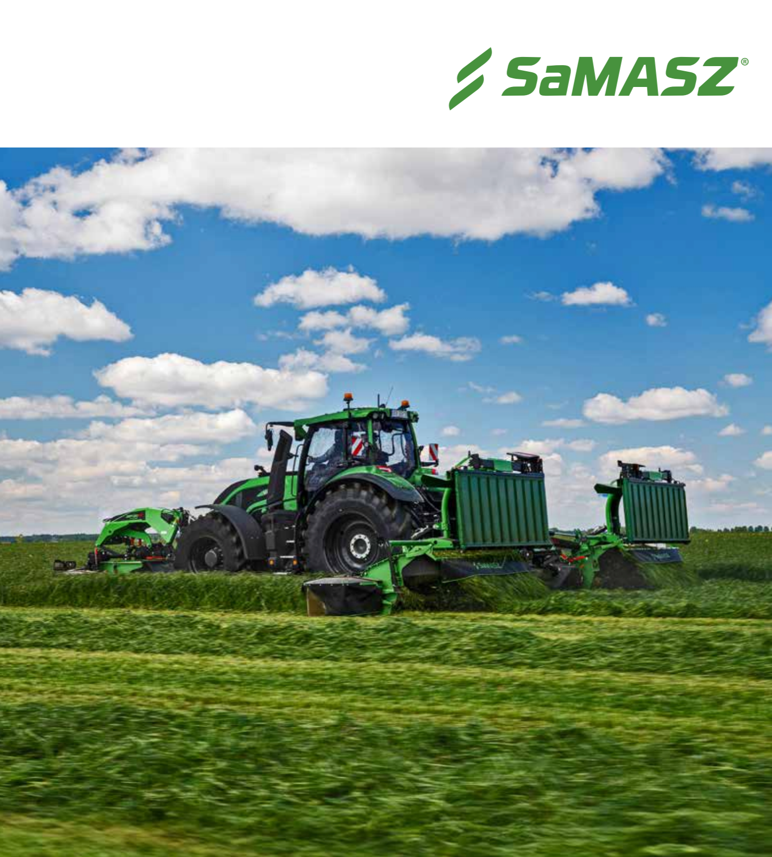 Green tractor with attached equipment working on a grassy field under a partly cloudy sky.