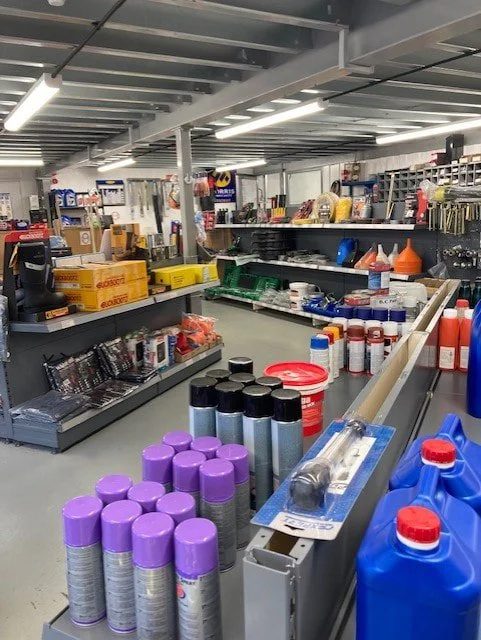 Shelves stocked with cleaning supplies, tools, and hardware items in a store aisle.