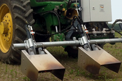 Front blades attached to a green tractor.