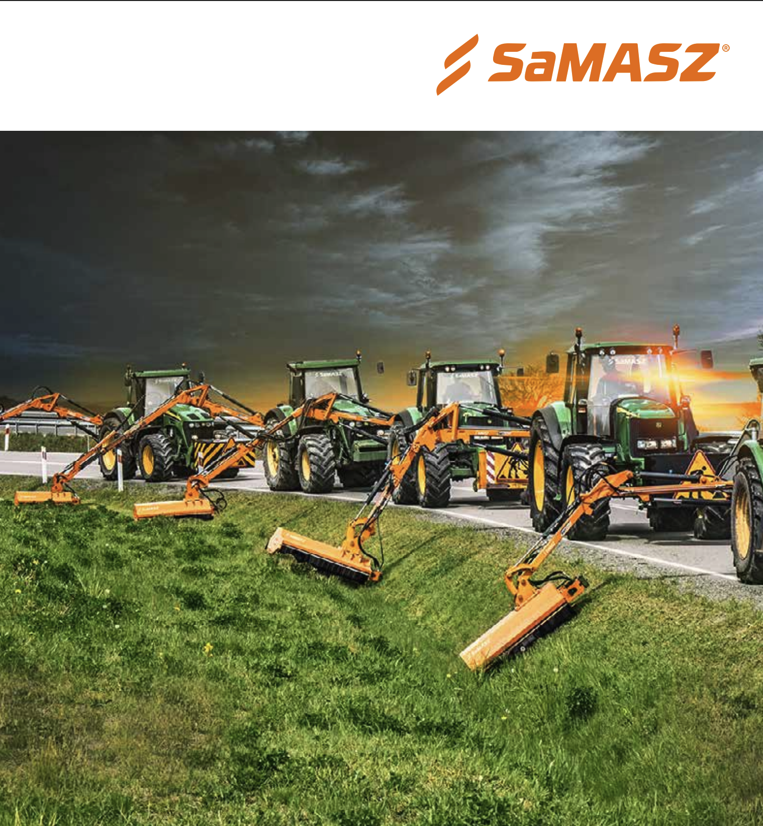 Multiple green and orange tractor mowers parked on a grassy area along a road, with dark cloudy sky overhead.