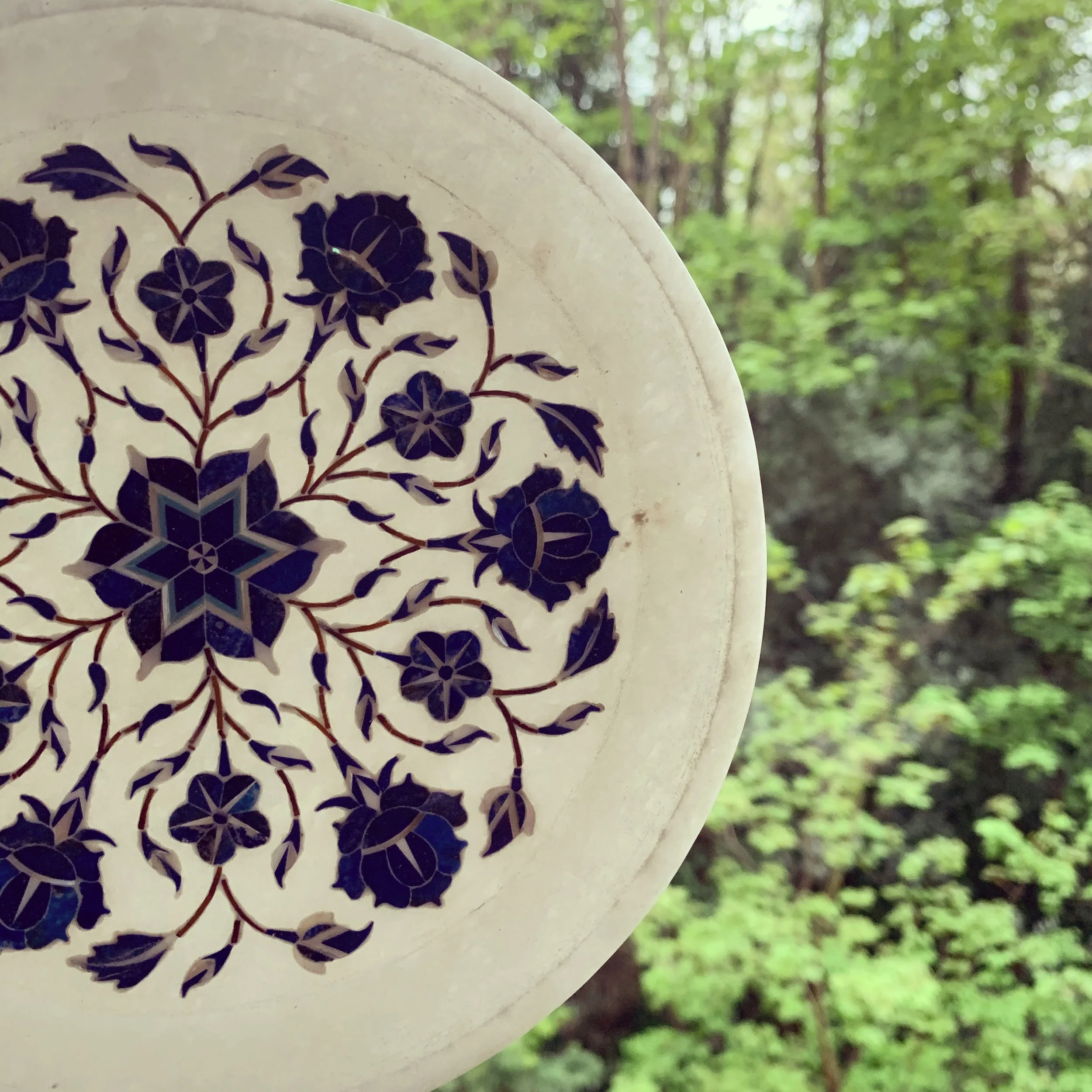 Handcrafted white marble plate featuring delicate blue floral inlay work