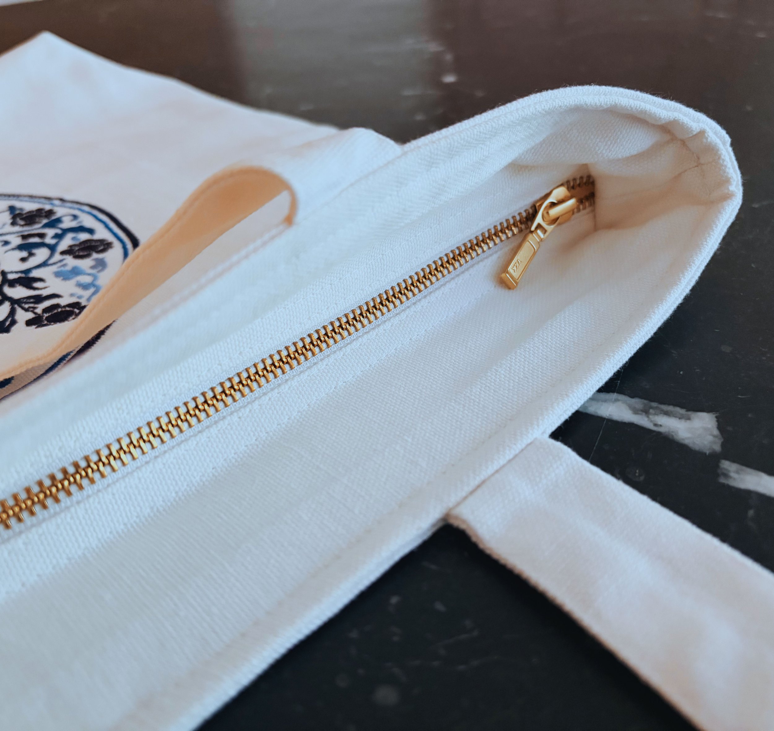 Blu Pietra embroidered tote bag showing YKK zip closure and inner lining detail