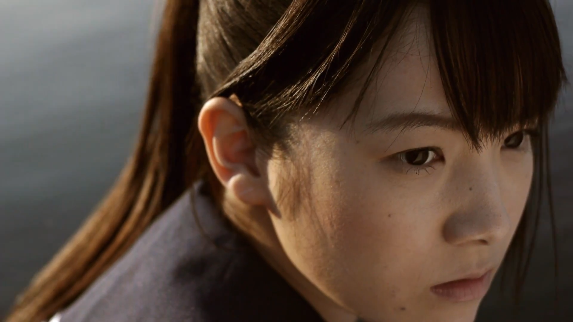 若い女性のクローズアップ。茶色の長い髪と静かな表情。