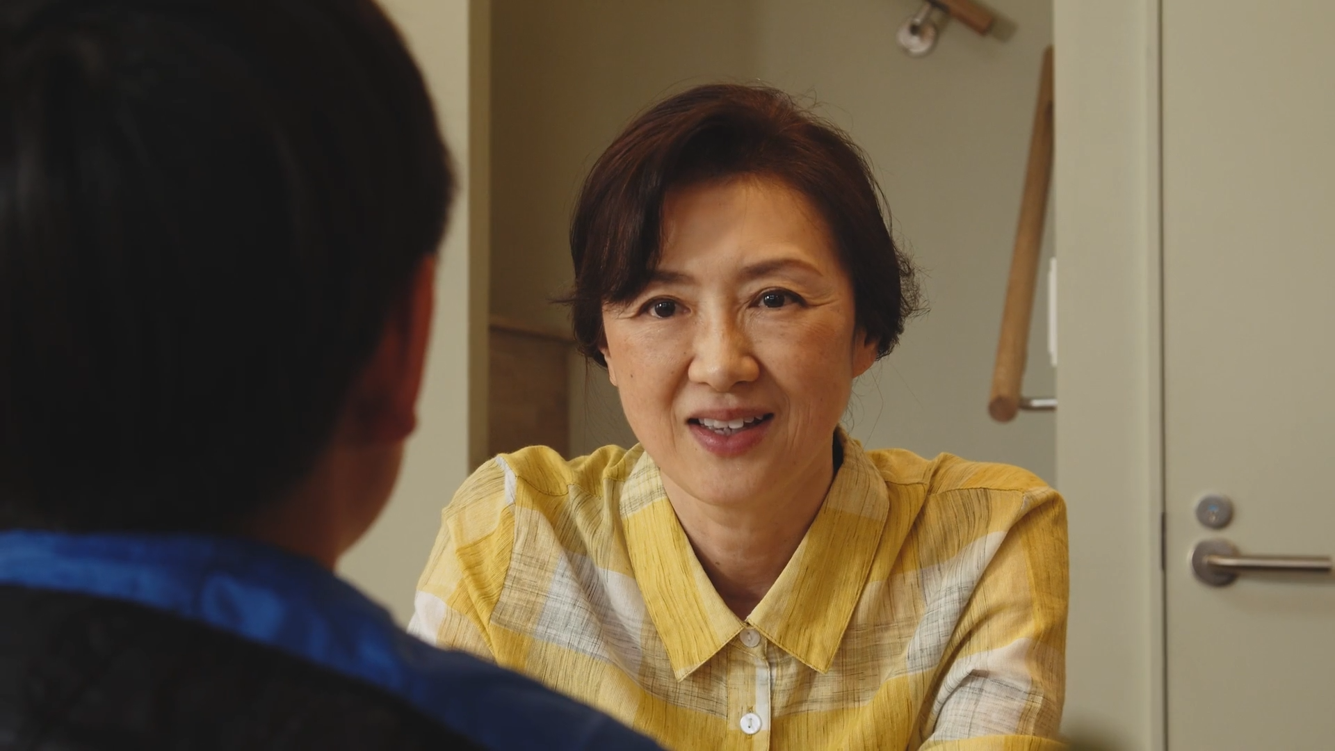 笑顔の中年女性が話すために話し相手の男性に向かって座っている場面