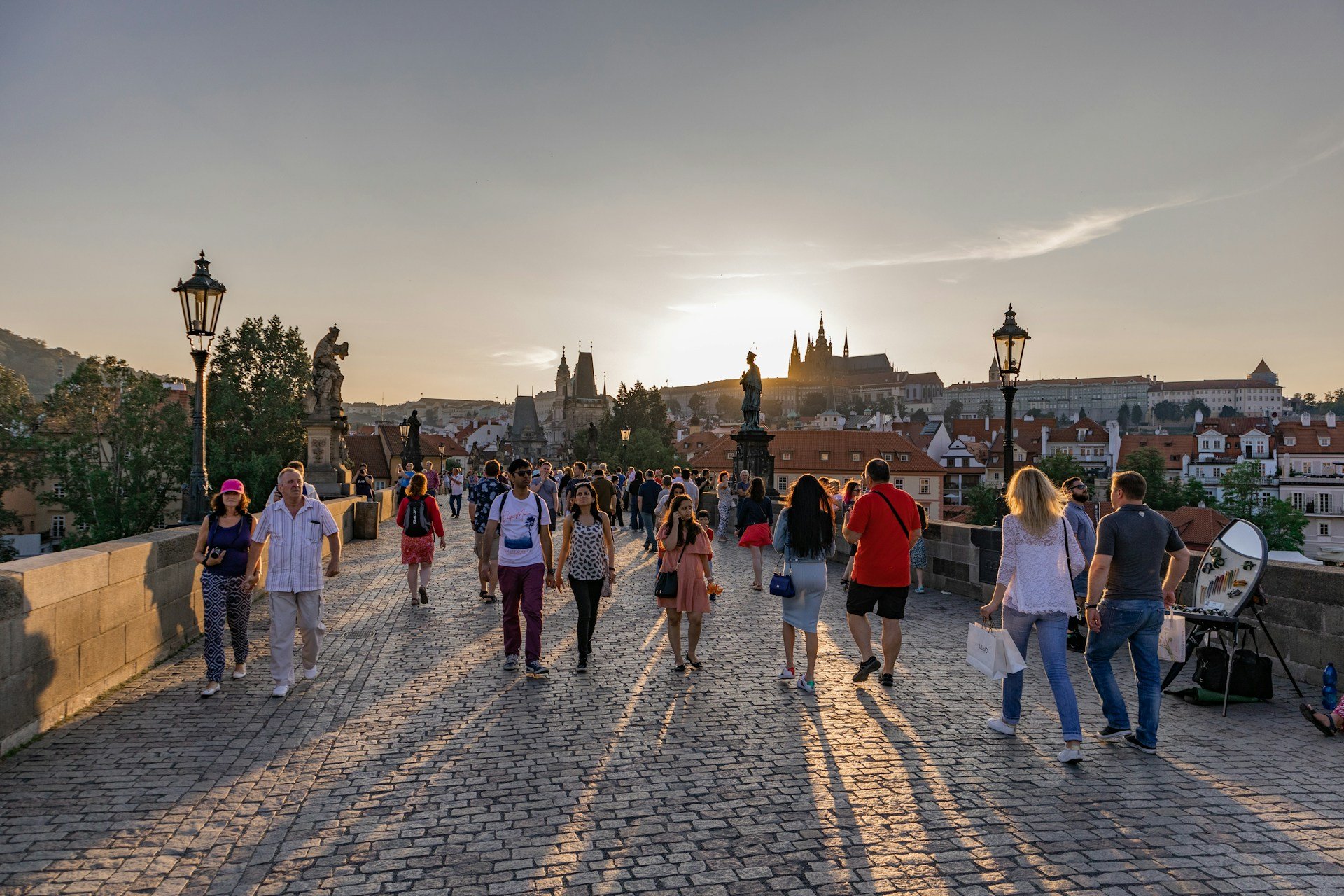 isitors walking across Charles Bridge in Prague