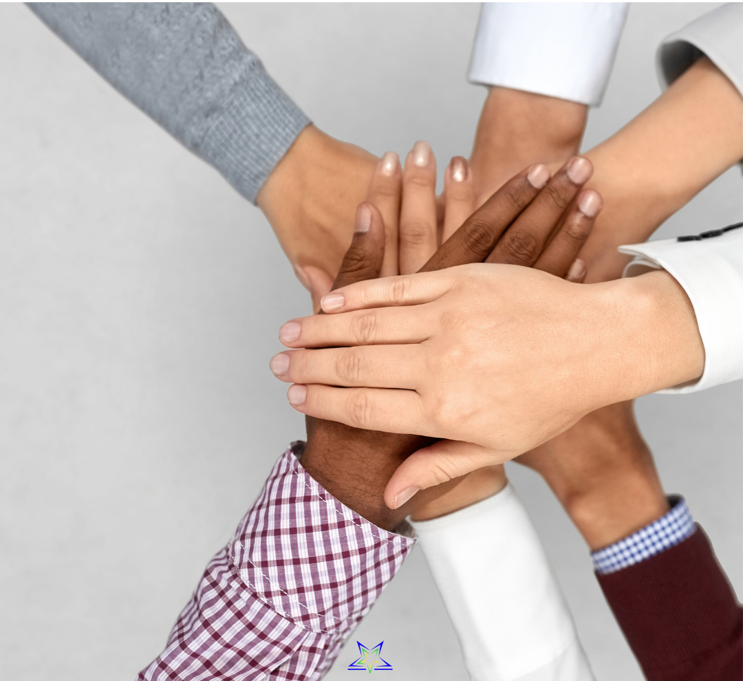 Image shows seven people who have placed their hands one on top of the other to form a stack